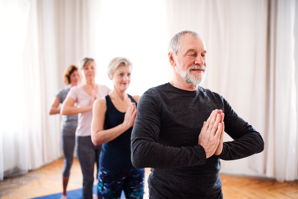A group of seniors practicing yoga at our Palm Springs memory care community