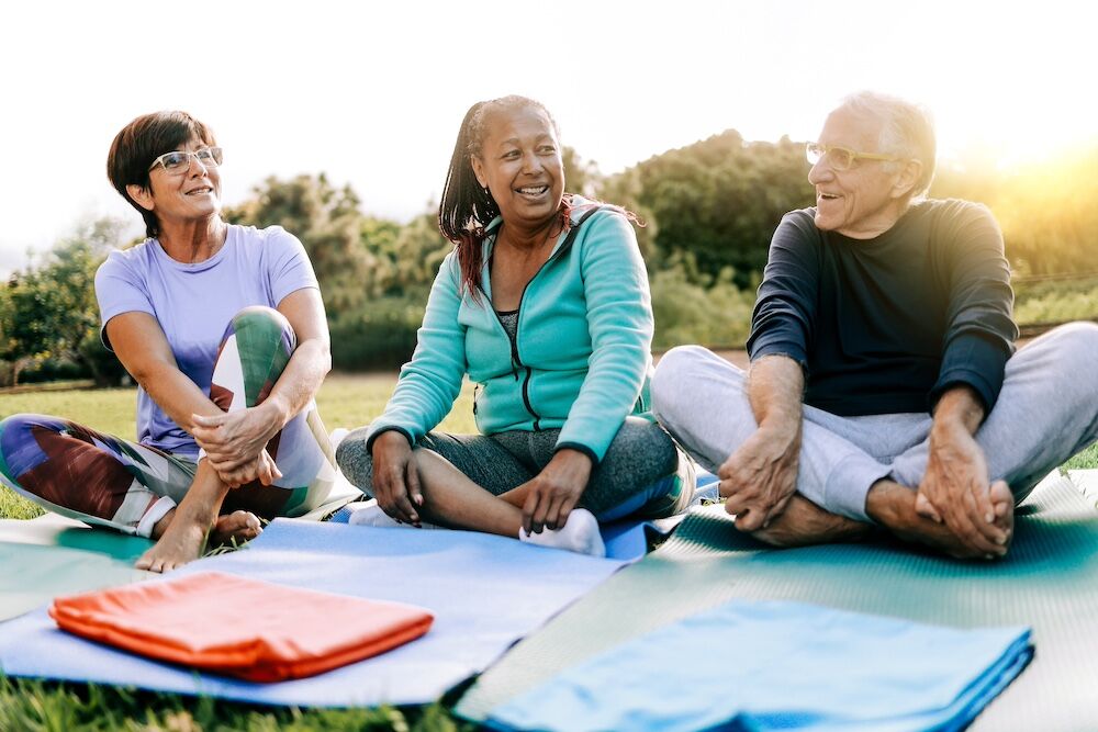 Three friends practicing yoga at the best senior living community in Rancho Mirage