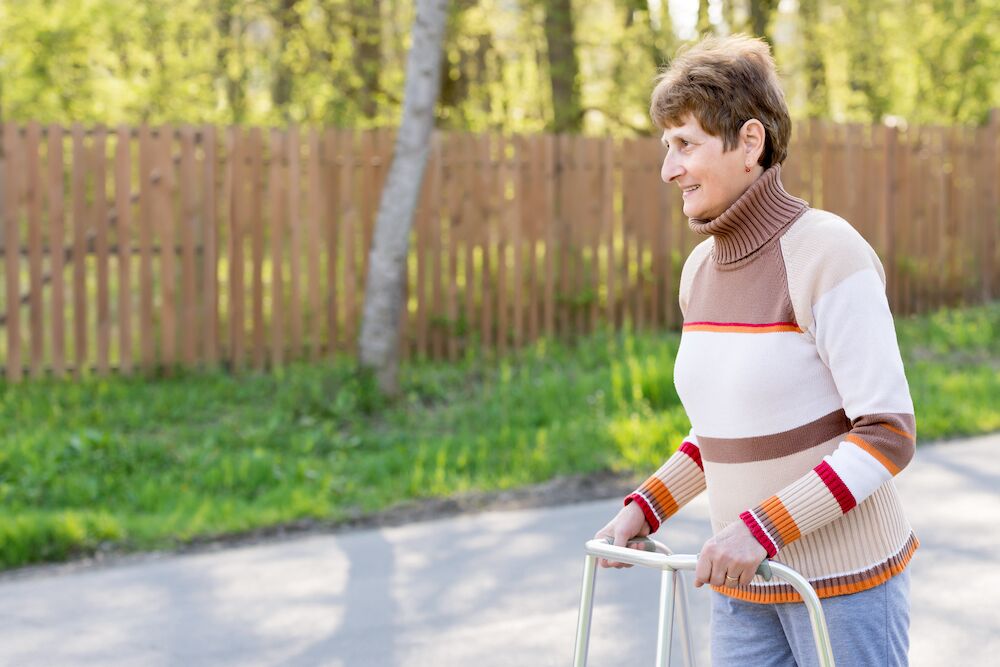 Senior woman using walker outdoors
