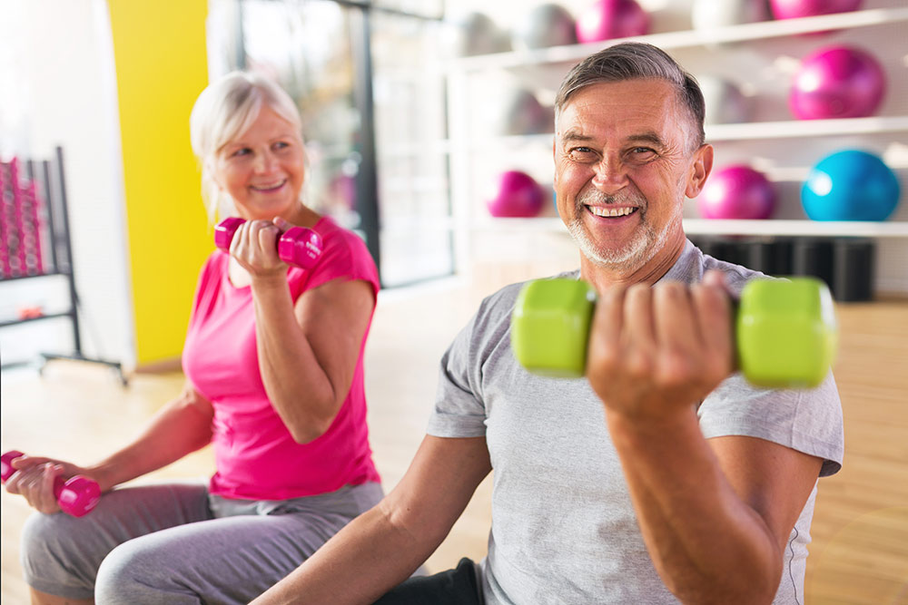 Senior couple working out, exercising, lifting free weights