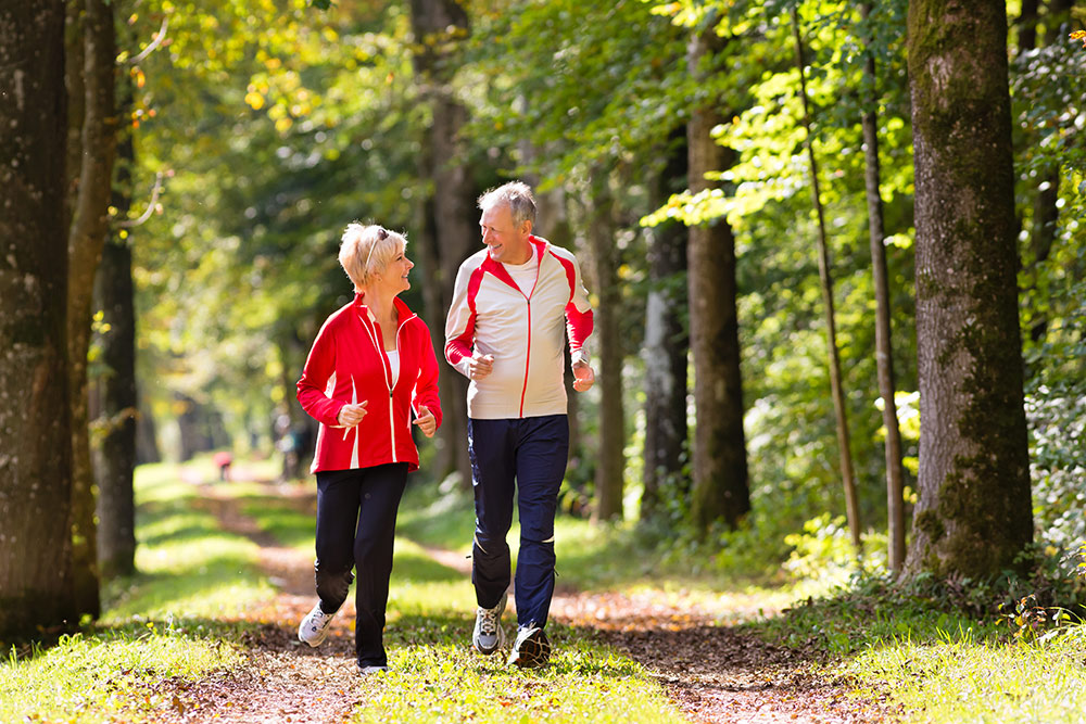 Senior couple happy and jogging outside in nice weather in senior living community in Rancho Mirage