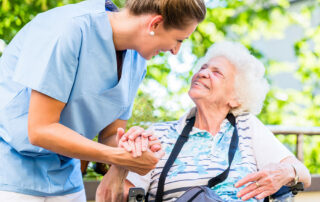 Senior woman smiling and looking up at caregiver in senior living community