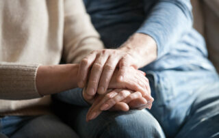 Senior hands holding caregiver hands