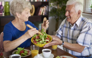 A senior couple enjoys eating a healthy meal