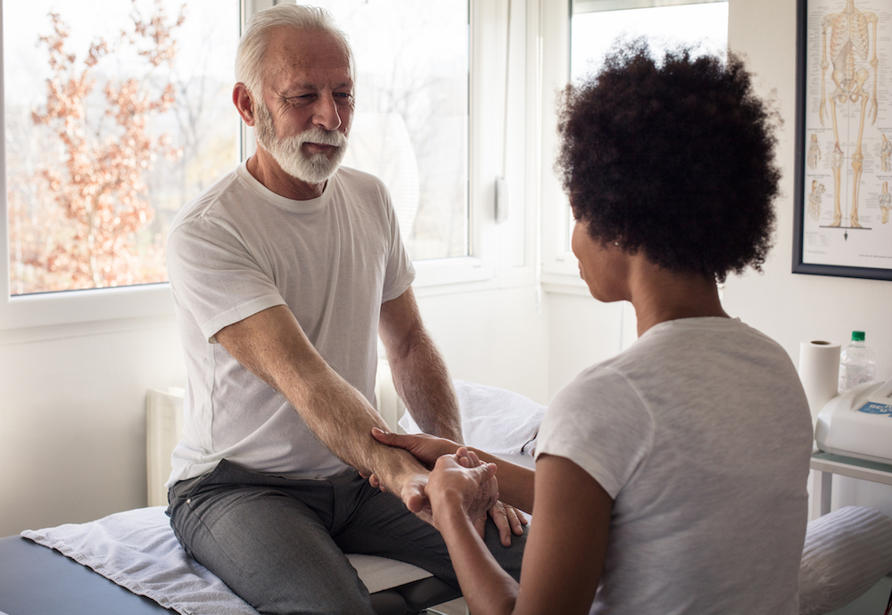 A senior man gets a hand massage