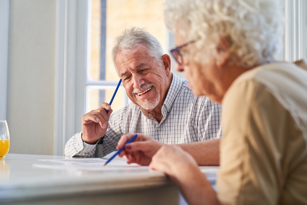 A senior couple does a crossword together while in memory care