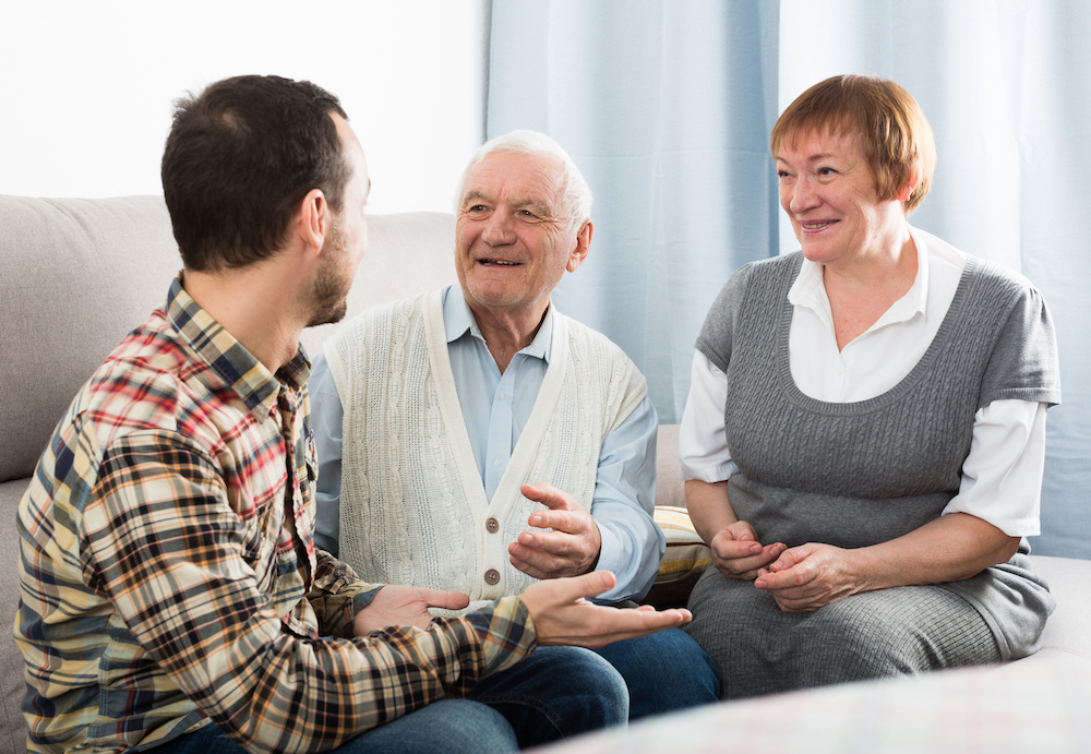 A man talks with his senior parents