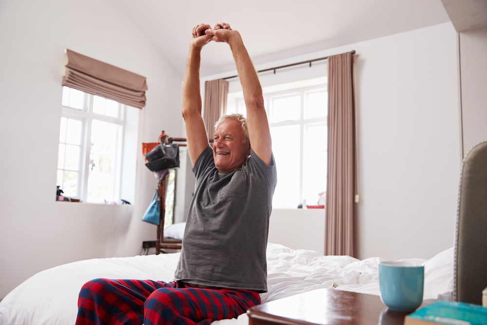 A senior man waking stretching after waking up