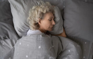 A senior woman asleep in bed