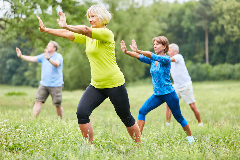 A group of senior practice tai chi in a park