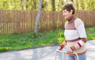 Senior woman using walker outdoors