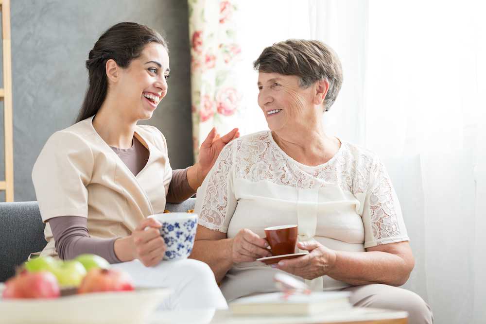 A Palm Springs senior living resident and caregiver enjoy tea together