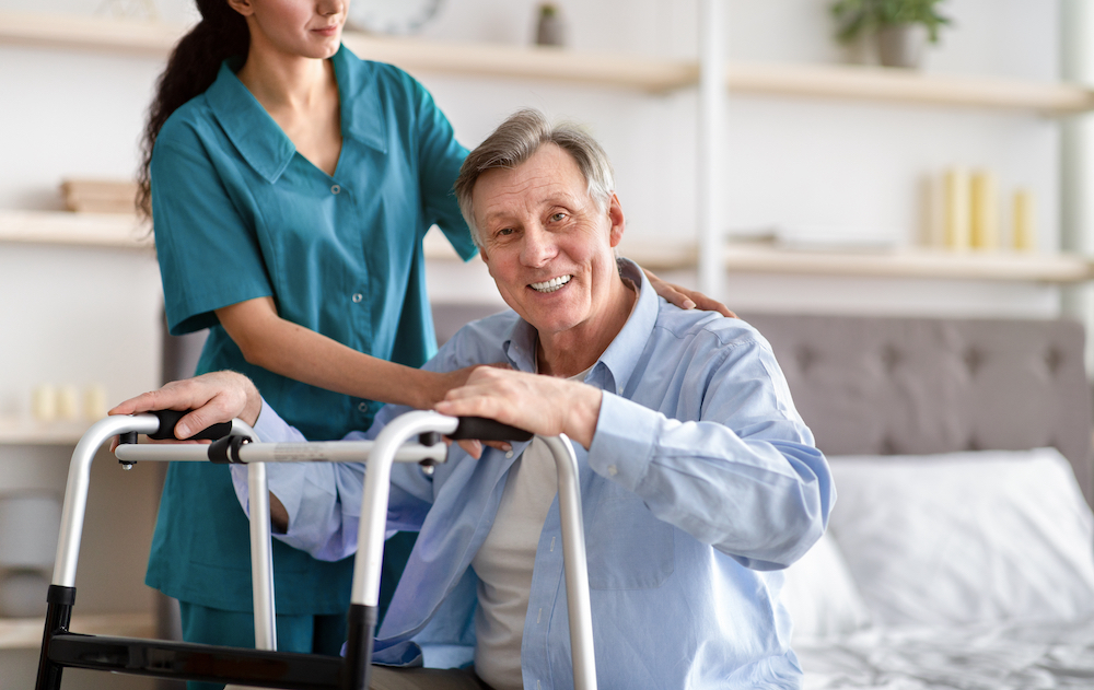 A caregiver helping a senior resident stand up