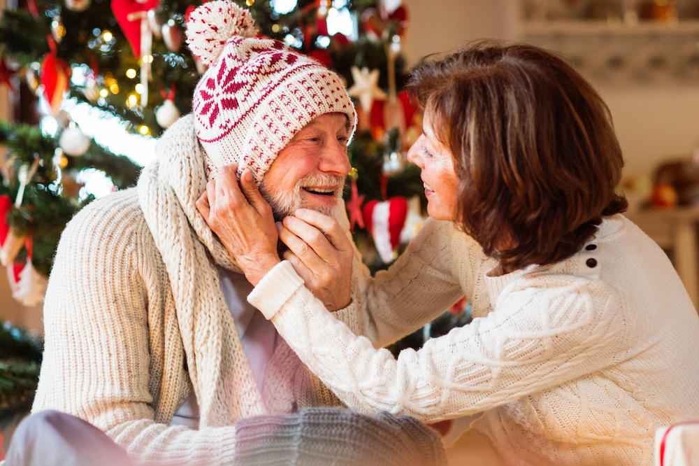 A woman putting on a knit cap for a senior at Palm Springs memory care