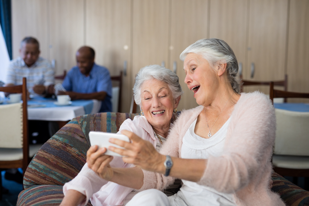 Two smiling senior women take a selfie together