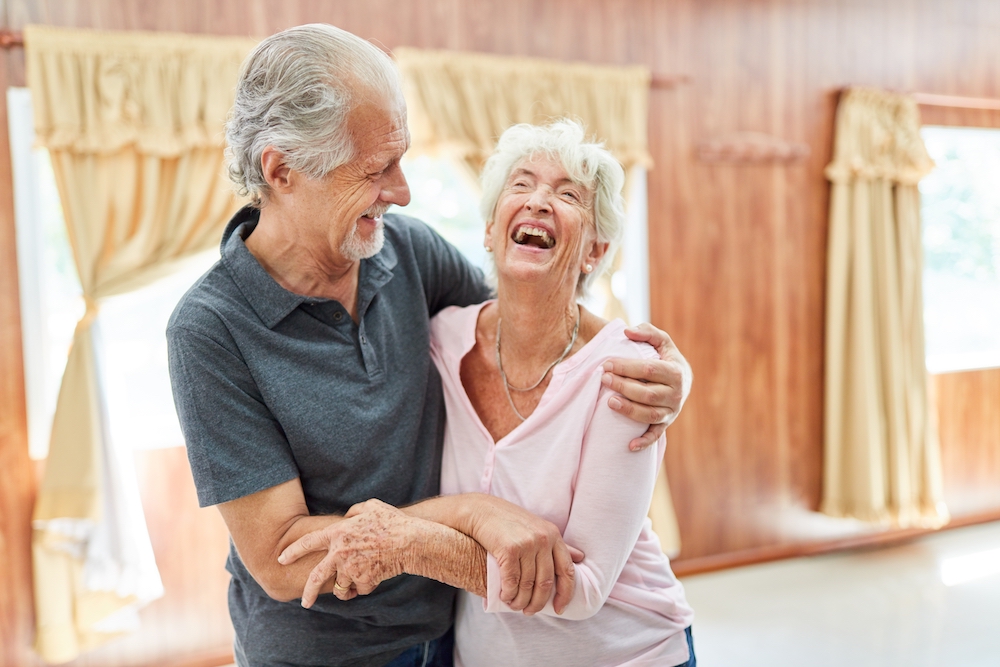 A joyful senior couple laughing and having fun at their Palm Springs senior living community