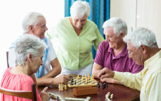 A group of friends play chess and dominos at the memory care in Palm Spring