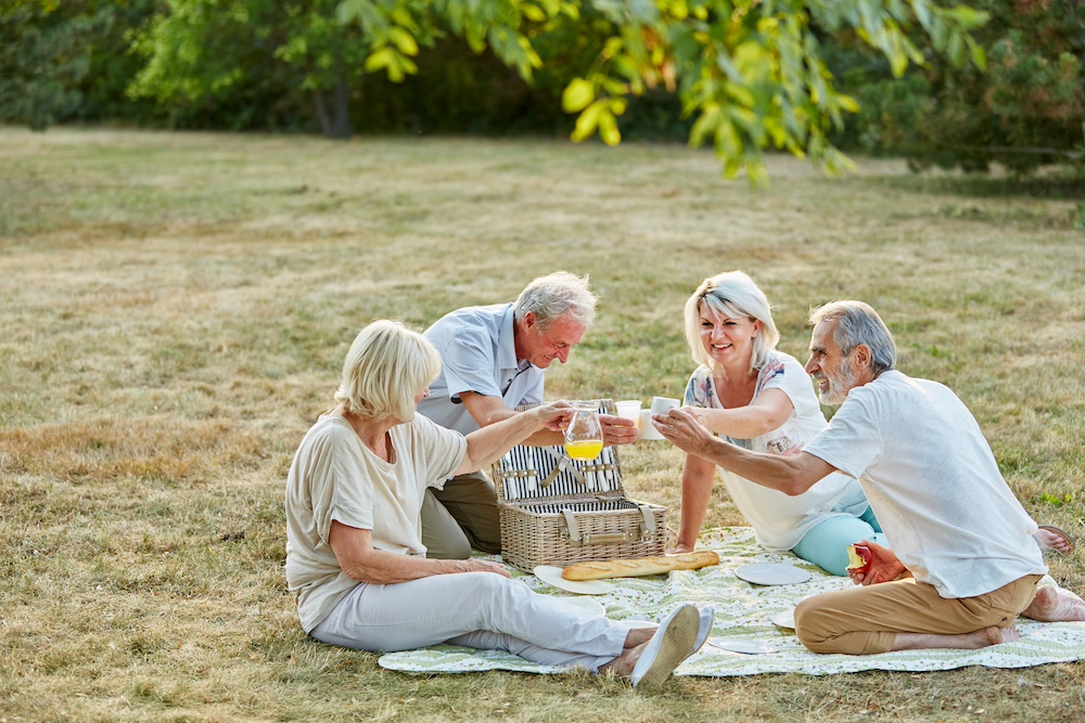 Older adult friends enjoy a picnic together outside of the senior living community in Rancho Mirage