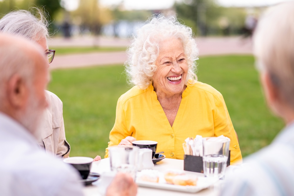 Senior woman outside with friends enjoying the dining services of assisted living rancho mirage