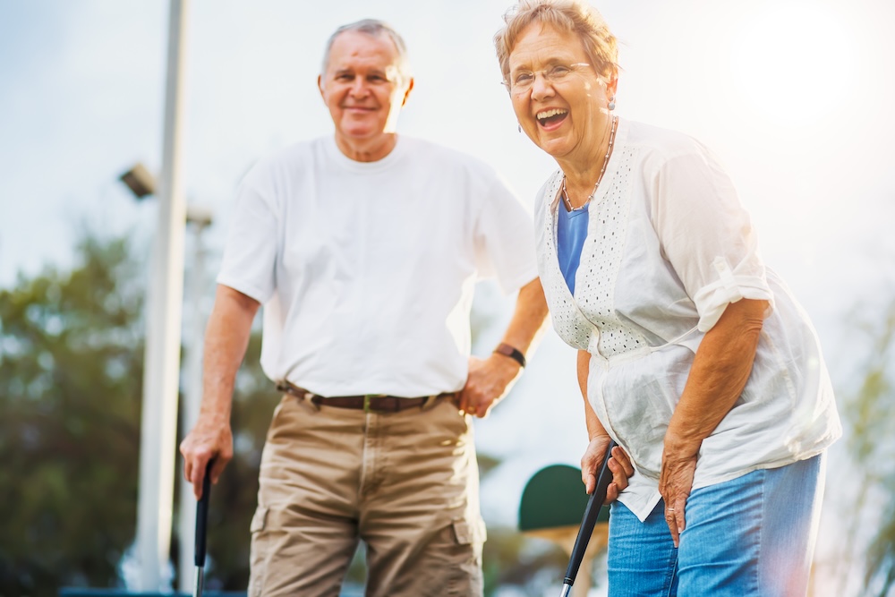 Happy senior couple playing golf as an activity at a senior care communities